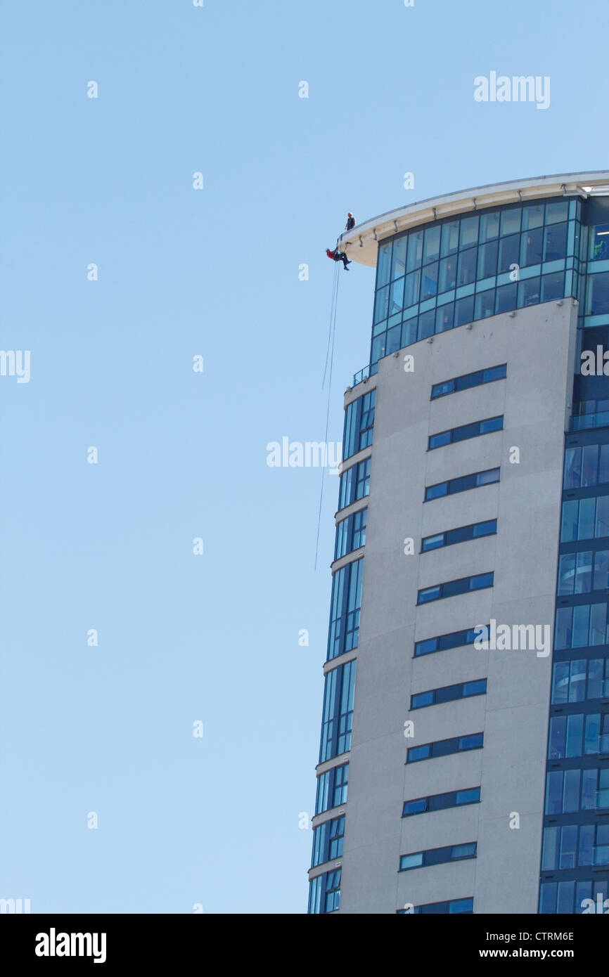 Wartungspersonal bei Abseilen Kabelbaum Swanseas neue Meridian-Turm in der Marina. Stockfoto