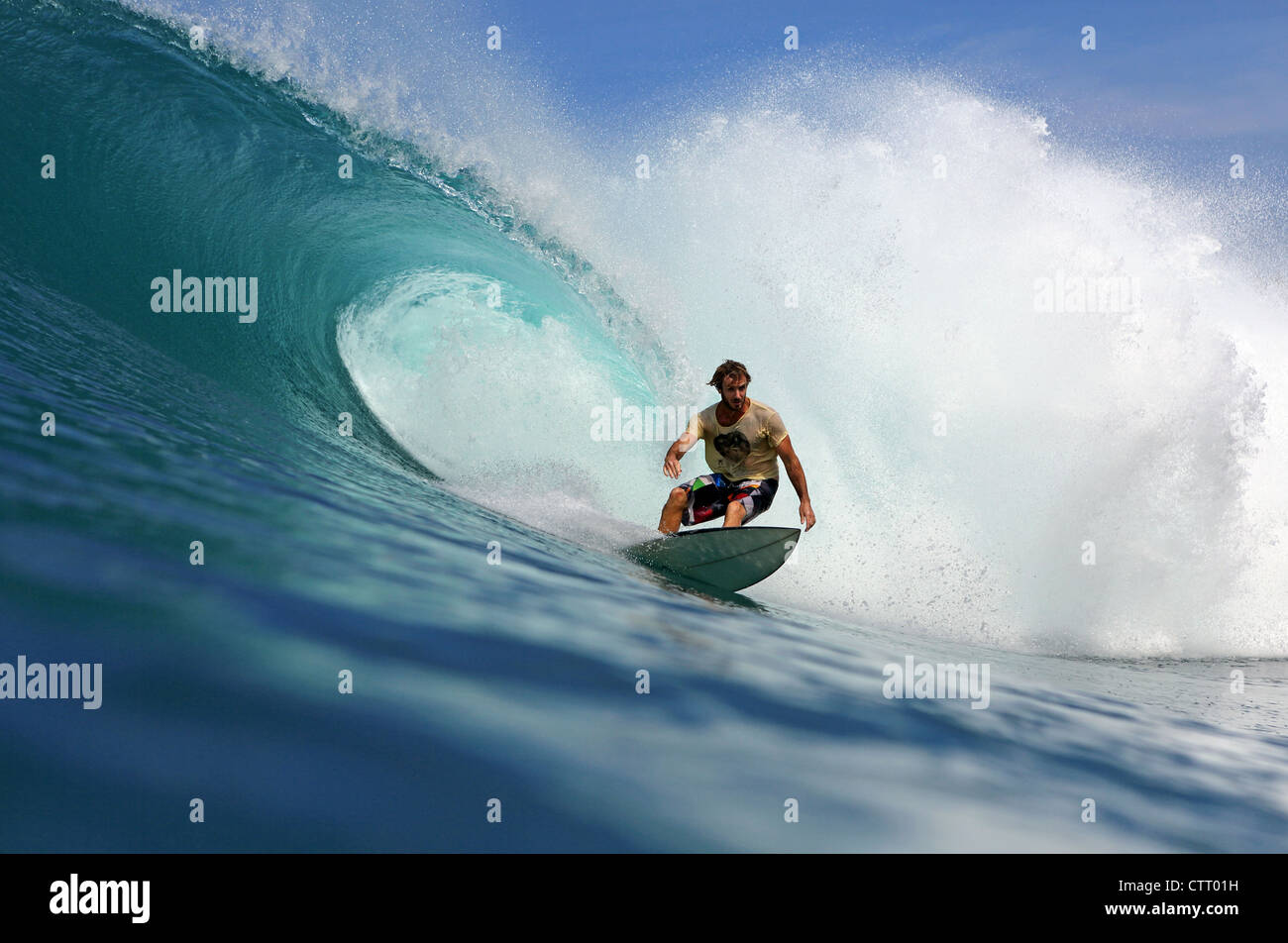 Australische Surfer eine große hohle Welle zu reiten, auf einem entfernten Riff brechen auf Nias Insel Sumatra. Stockfoto