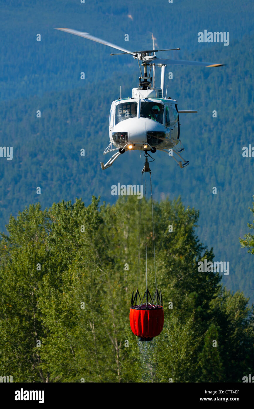 Feuerwehr-Hubschrauber heben einer Last des Wassers Stockfoto