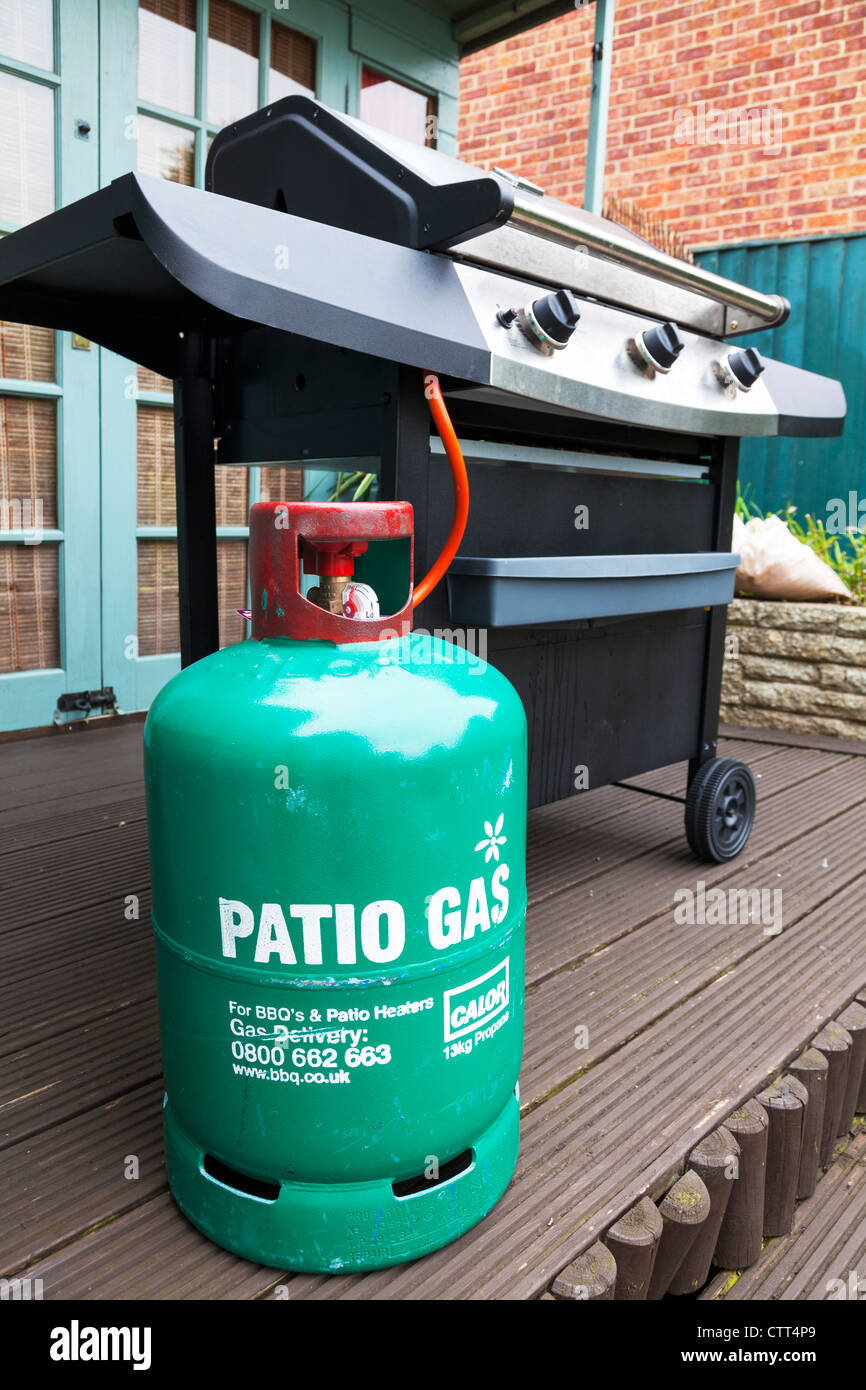 Grünen Zylinder Propan Calor Terrasse Gasflasche Flasche & Barbecue auf der Terrasse Stockfoto