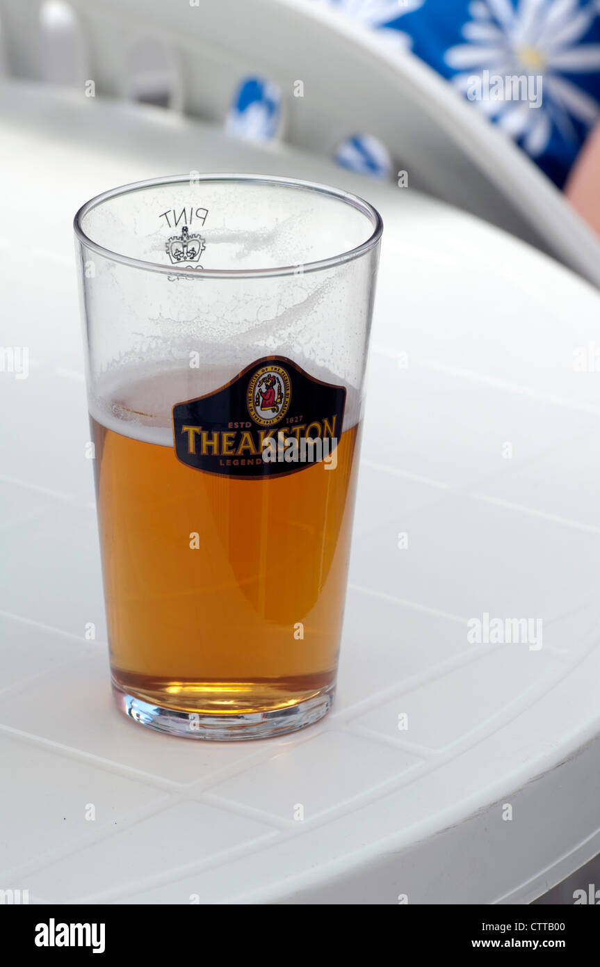 Pint Glas Bier, halb voll Stockfoto