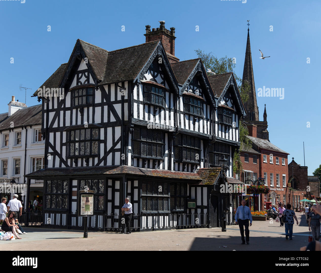 Schwarzen & weißen Fachwerkhaus an Hauptverkehrsstraße in Stadt von Hereford mit Kirchturm im Hintergrund. Stockfoto