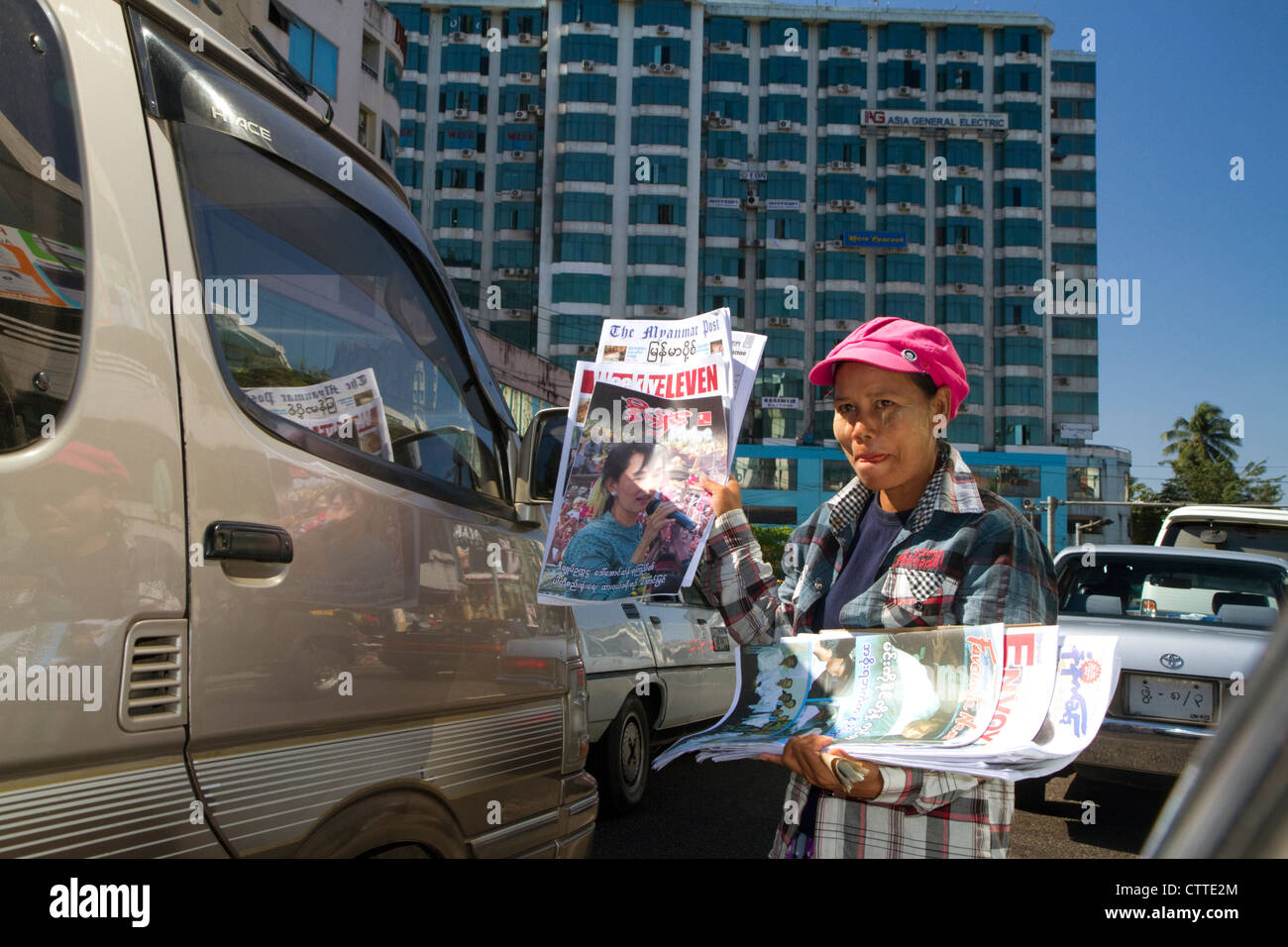 Burmesische Frau stehen im Stau, Verkauf von Zeitungen in Yangon (Rangoon), Myanmar (Burma). Stockfoto