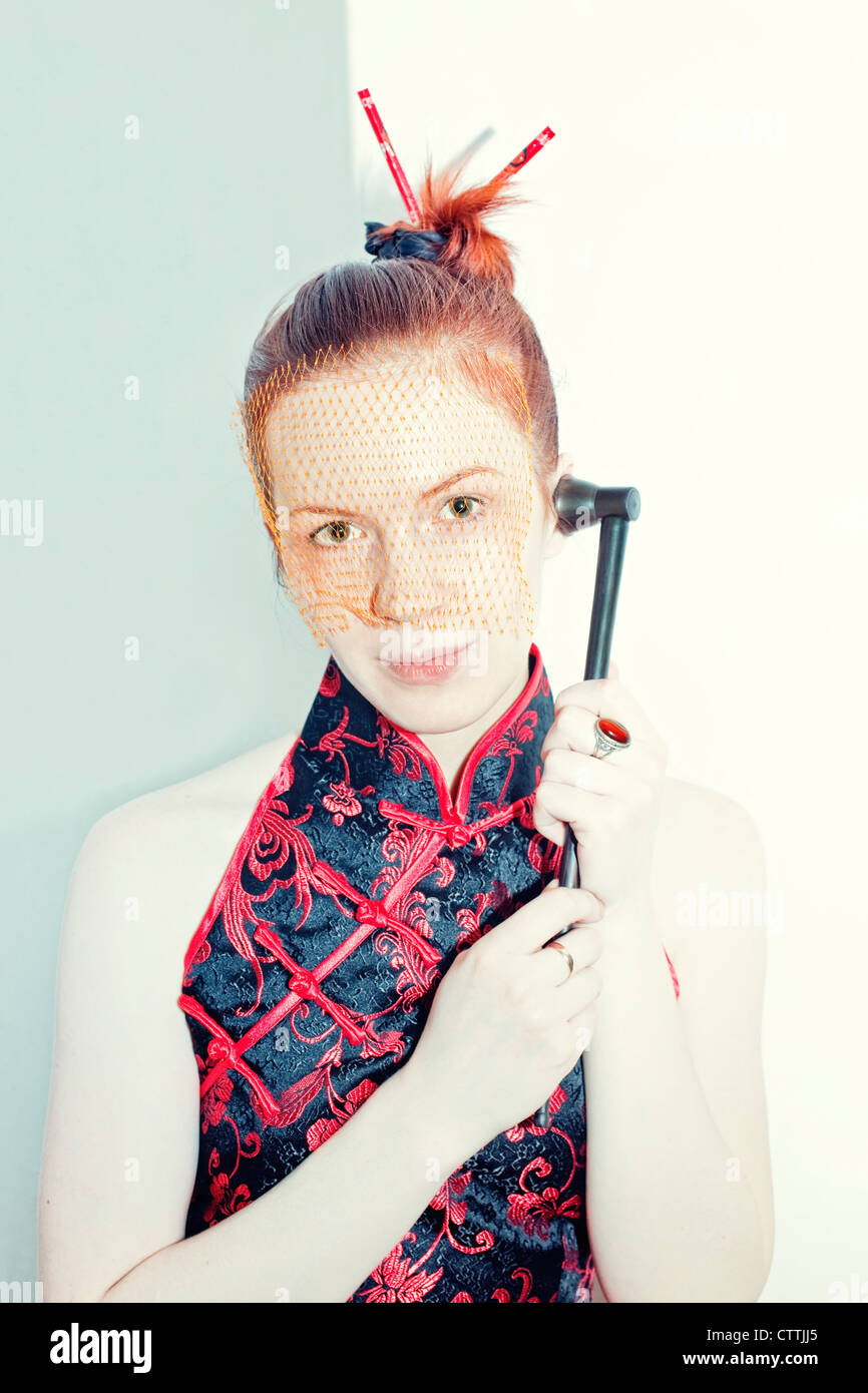 Porträt einer jungen Frau in einem japanischen Kleid und Schleier mit einem Rohr Stockfoto
