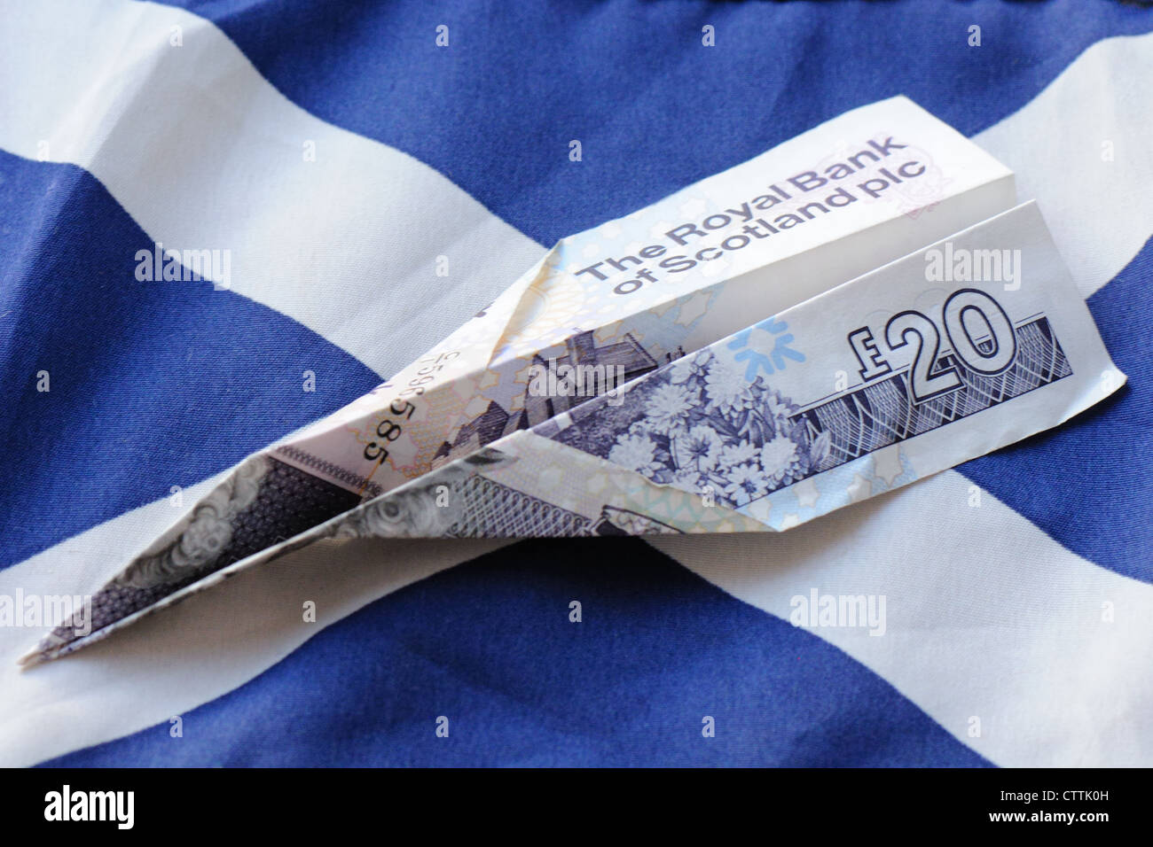 Königliche Bank von Schottland 20-Pfund-Note gefaltet, Papierflieger auf schottische Flagge zu machen Stockfoto