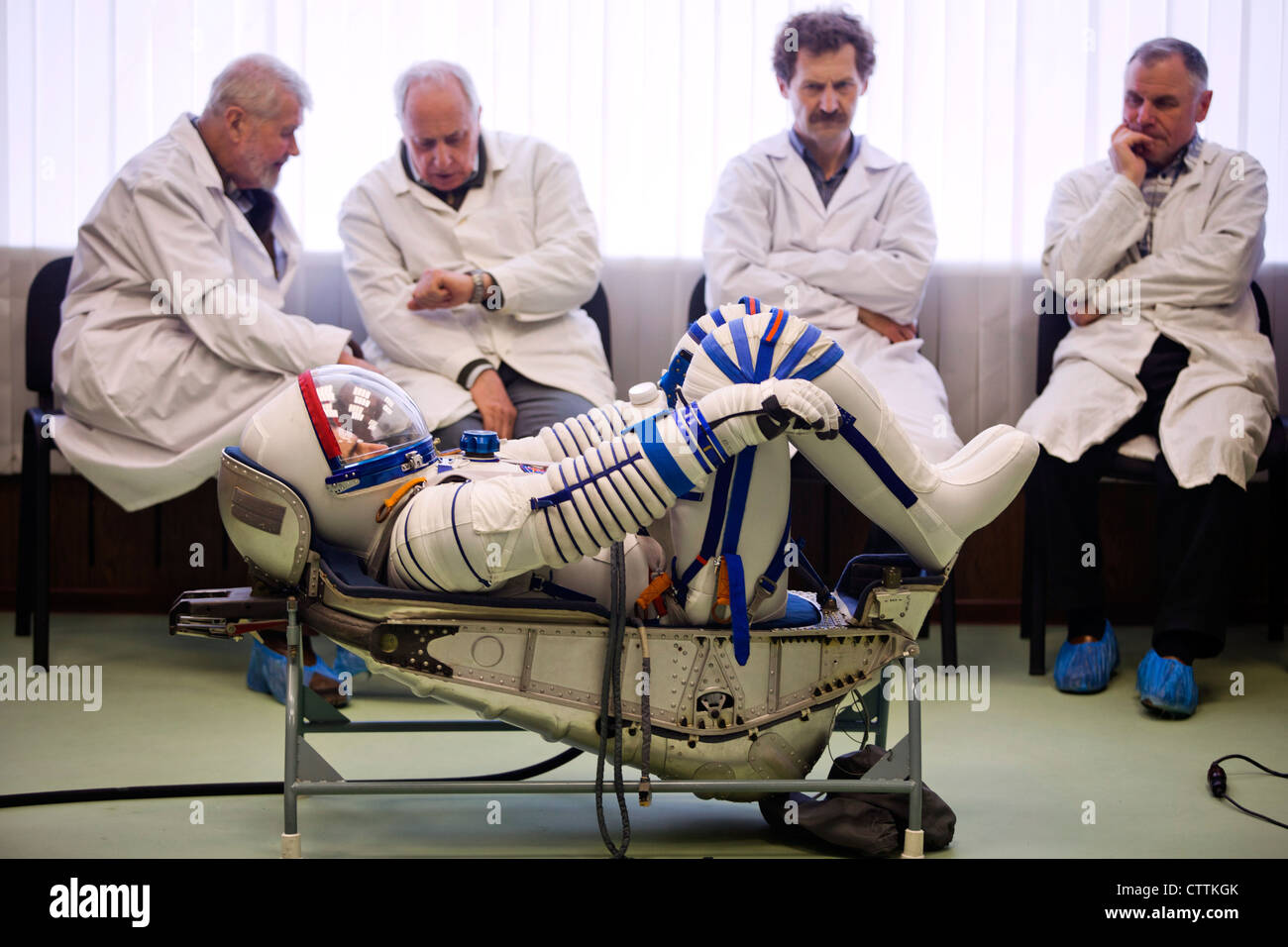 NASA-Astronaut Rex Walheim (Vordergrund), STS-135-Missionsspezialist, wird am 28. März 2011 in der Moskauer Zvezda-Anlage einer Passkontrolle seines Sokol-Raumanzugs unterzieht. Die Crew der letzten Shuttle-Mission reiste nach Moskau, um ihre russischen Sokol-Anzüge im Notfall zu überprüfen. Stockfoto