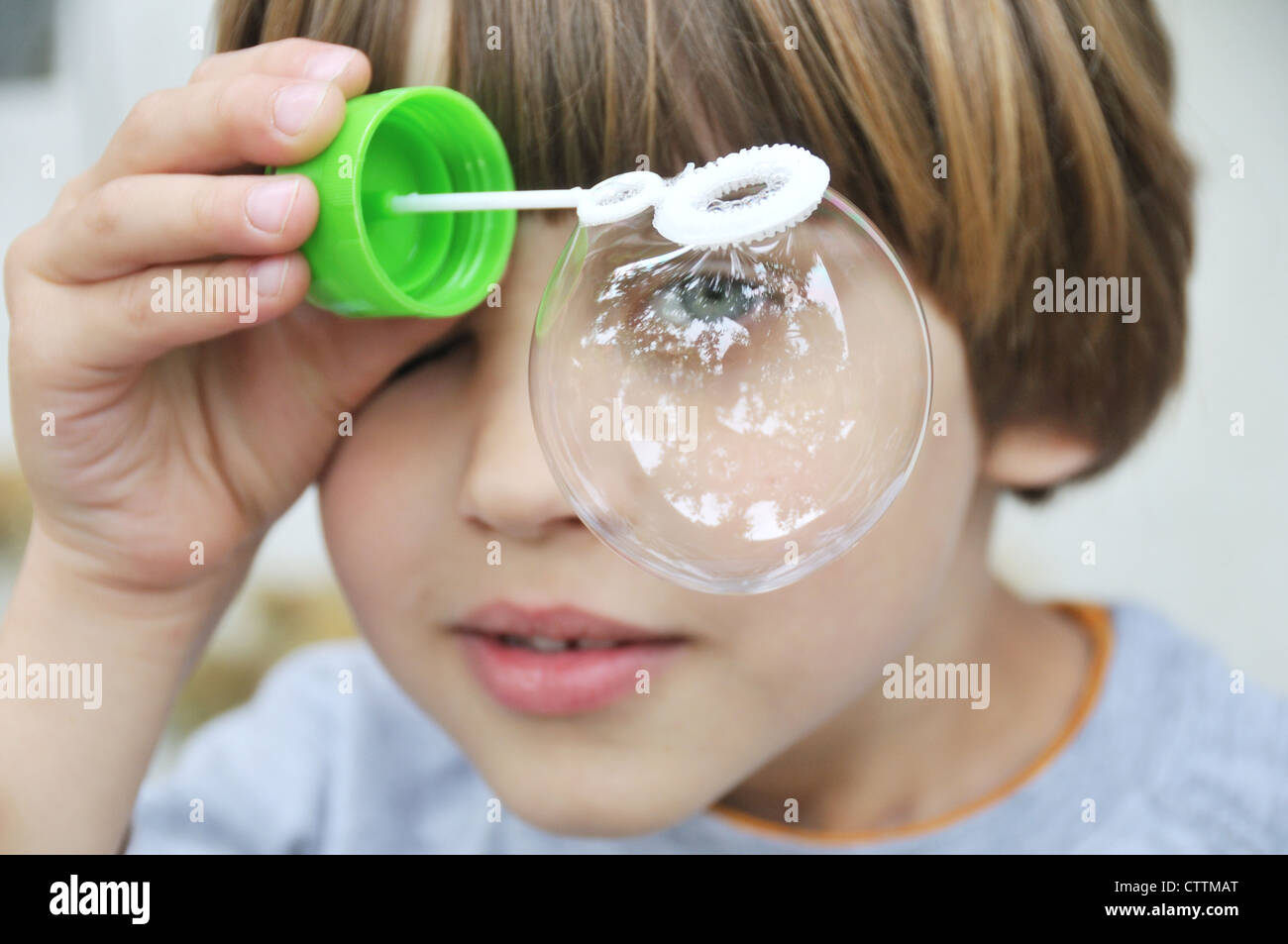 Ein Junge spielt mit Blase Gebläse Stockfoto