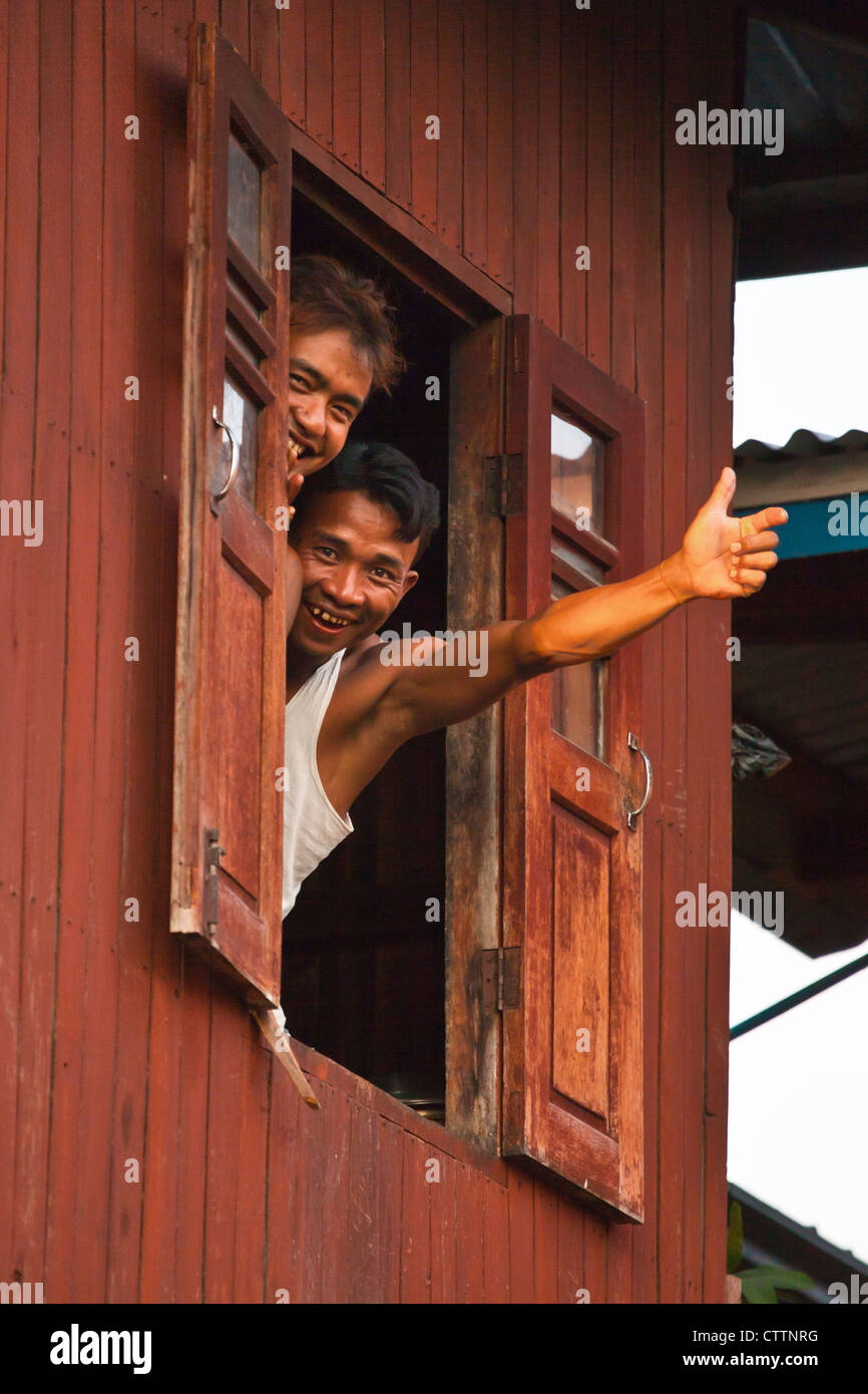 Junge Männer sagen Hallo aus einem Fenster in das Dorf von PWE SAR KONE - INLE-See, MYANMAR Stockfoto