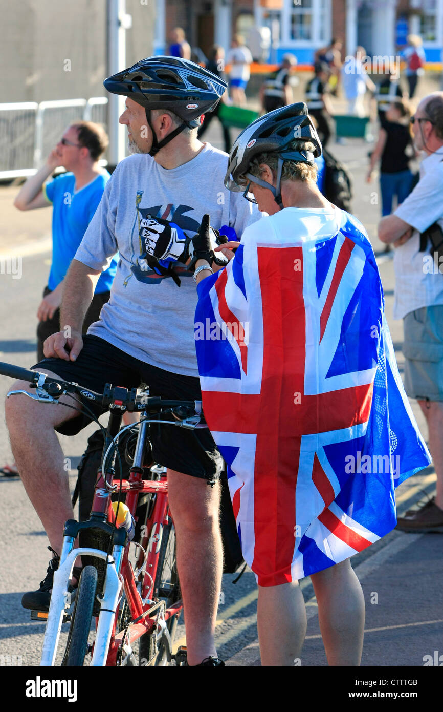Zwei Radfahrer Helme tragen stoppen, um ihre Unterstützung von GB zu zeigen, mit einem binden eine britische Flagge um sich herum Stockfoto