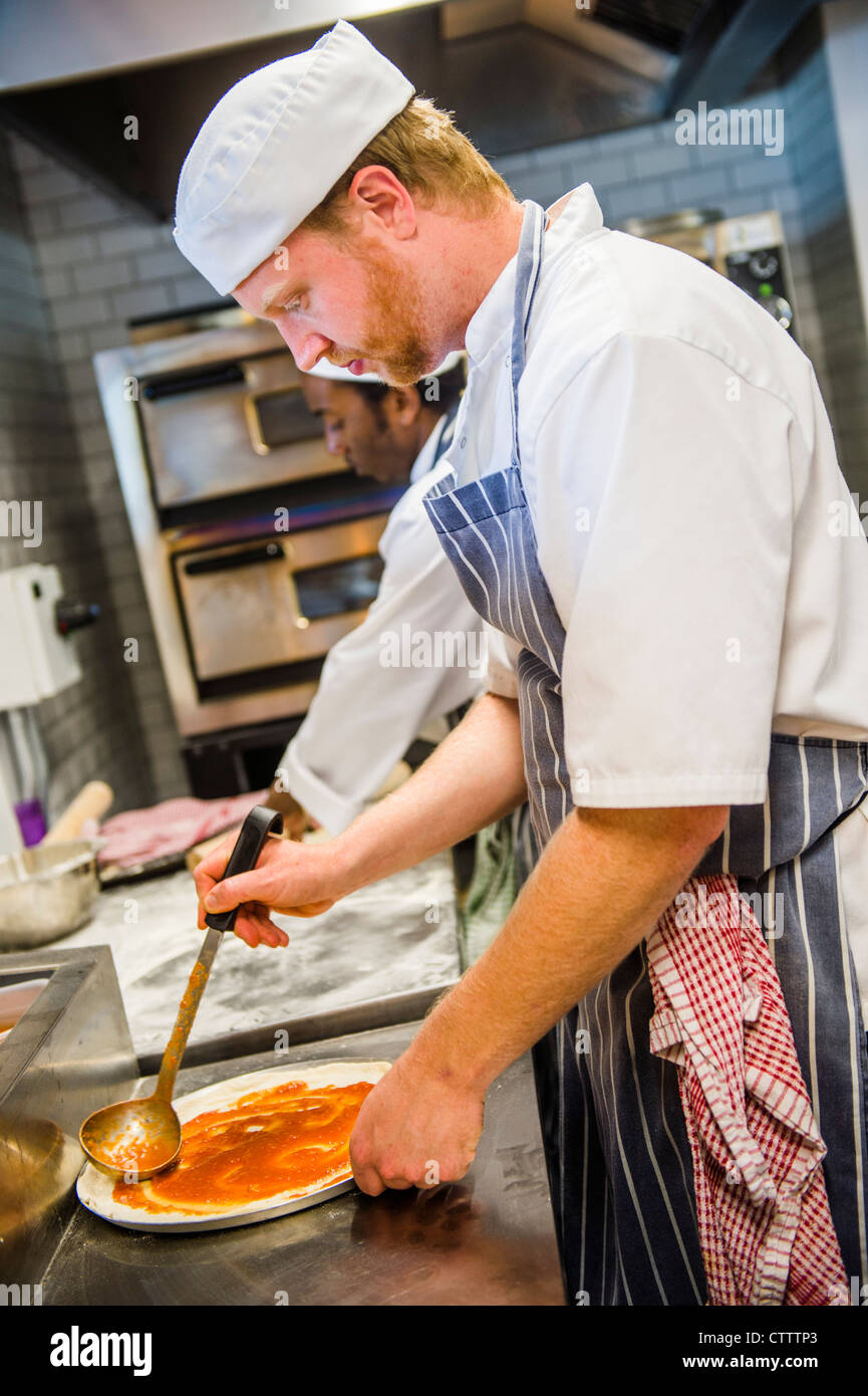Ein Koch bereitet eine Pizza in BARAVIN, eine neue Pizzeria Café bar Bistrorestaurant in Aberystwyth, Wales, UK Stockfoto