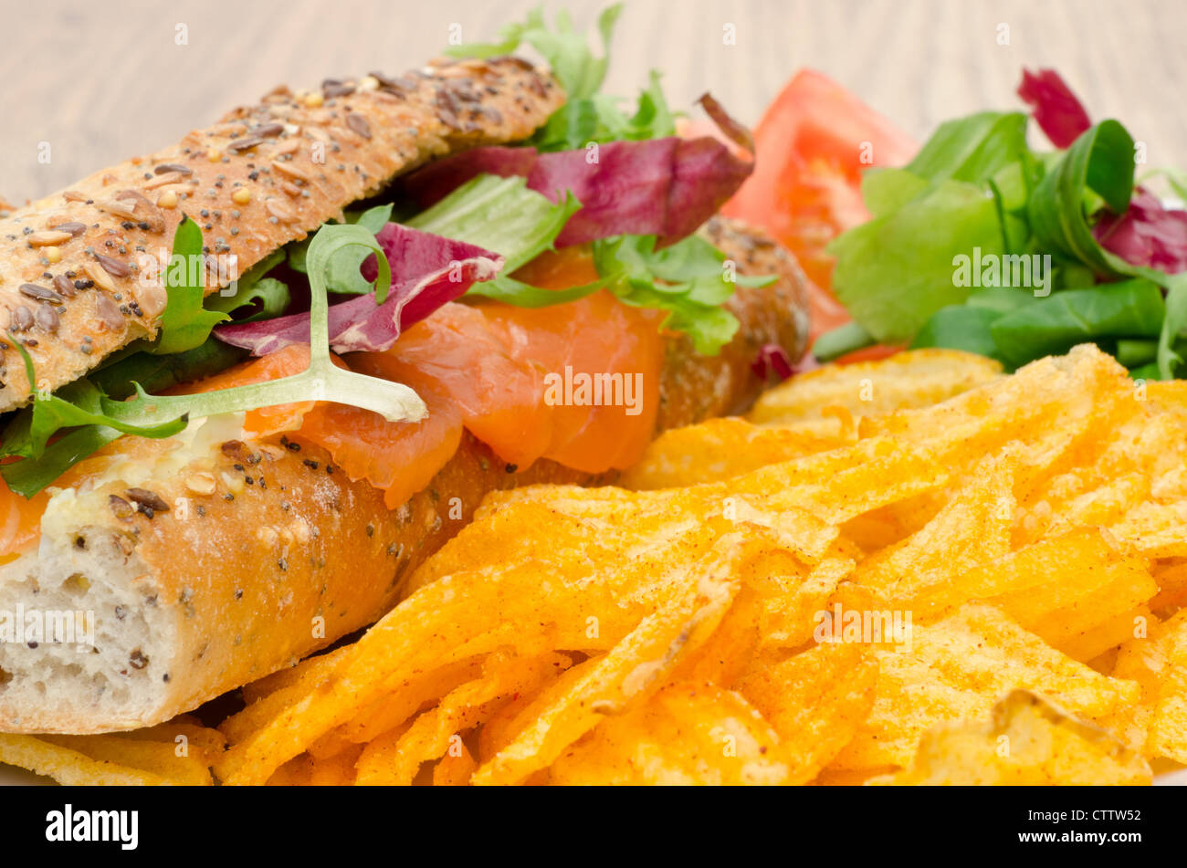 Baguette, gefüllt mit Frischkäse und geräucherter Lachs mit Salat und aromatisierten Chips - Studio gedreht Stockfoto