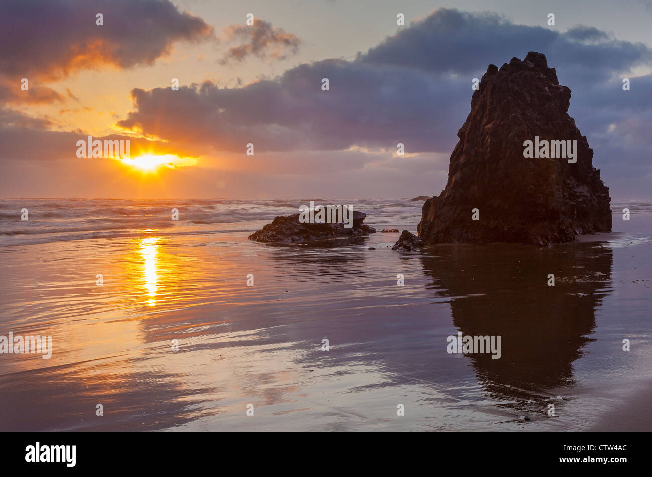 Ecola State Park, Oregon-Sonnenuntergang-Reflexionen und Silhouette Seastacks auf Indian Beach Stockfoto