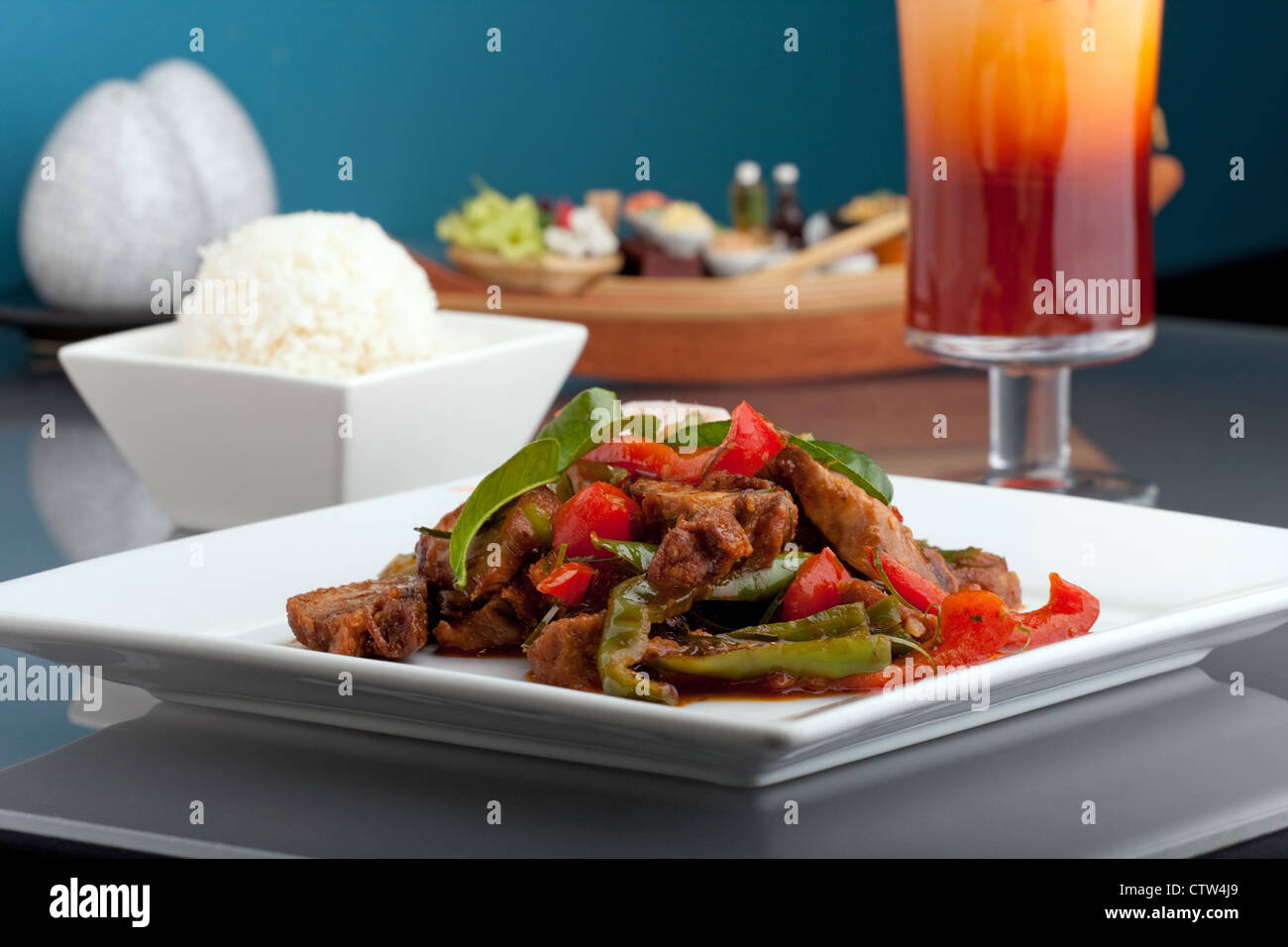 Ein frisches Gericht der Thai-Stil Chile Basilikum Ente mit gemischtem Gemüse weiße klebrige Jasminreis und thai Eistee. Stockfoto
