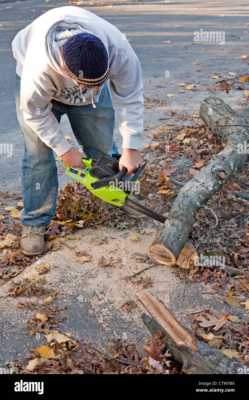 Mann mit einer Kettensäge, um nach einem Sturm gefallenen Äste und Zweige zu schneiden. Stockfoto