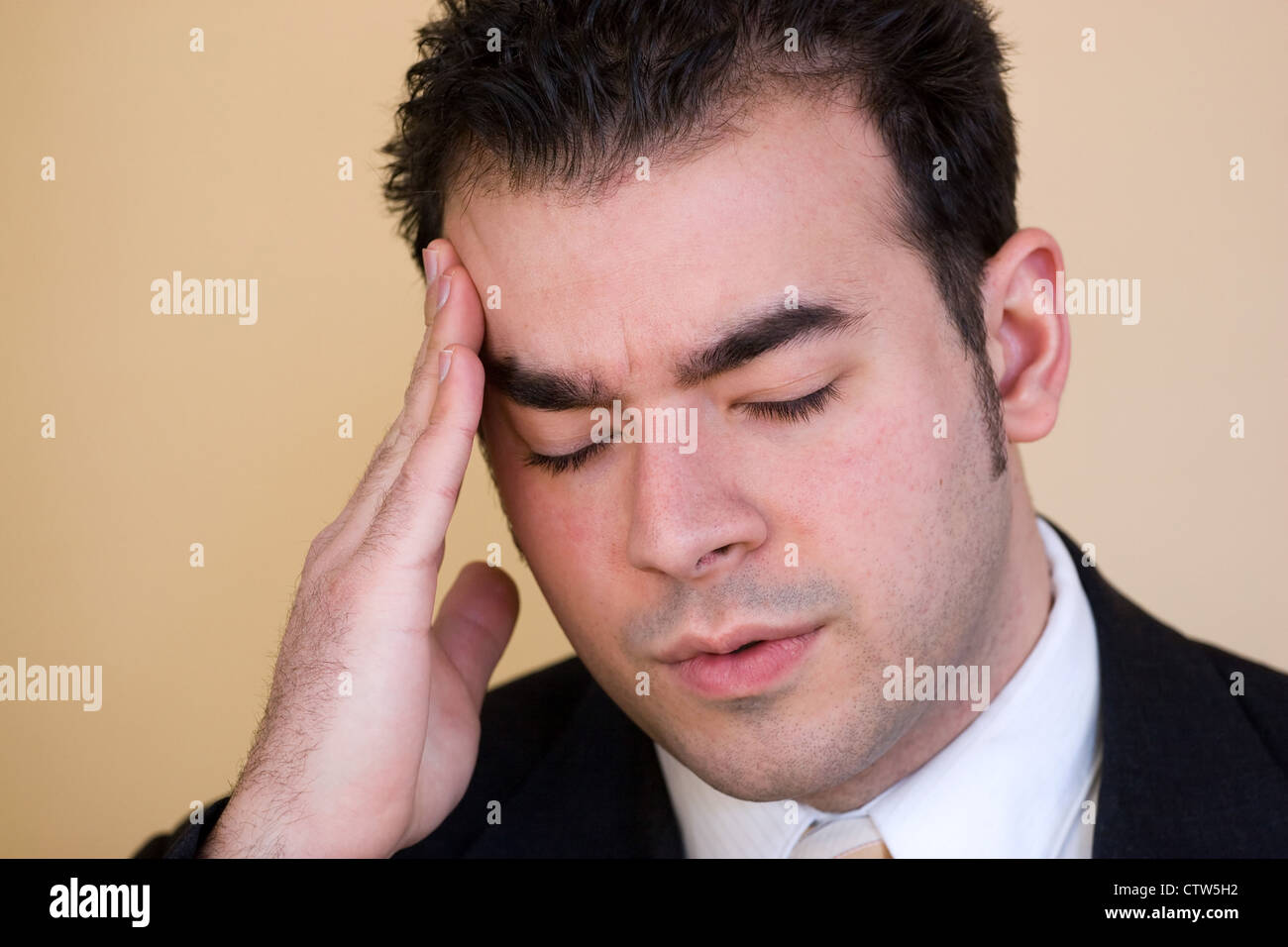 Junger Mann mit Kopfschmerzen. Er könnte intensiven Belastung über eine Zeit des wirtschaftlichen Abschwungs oder andere finanzielle Not erleben. Stockfoto