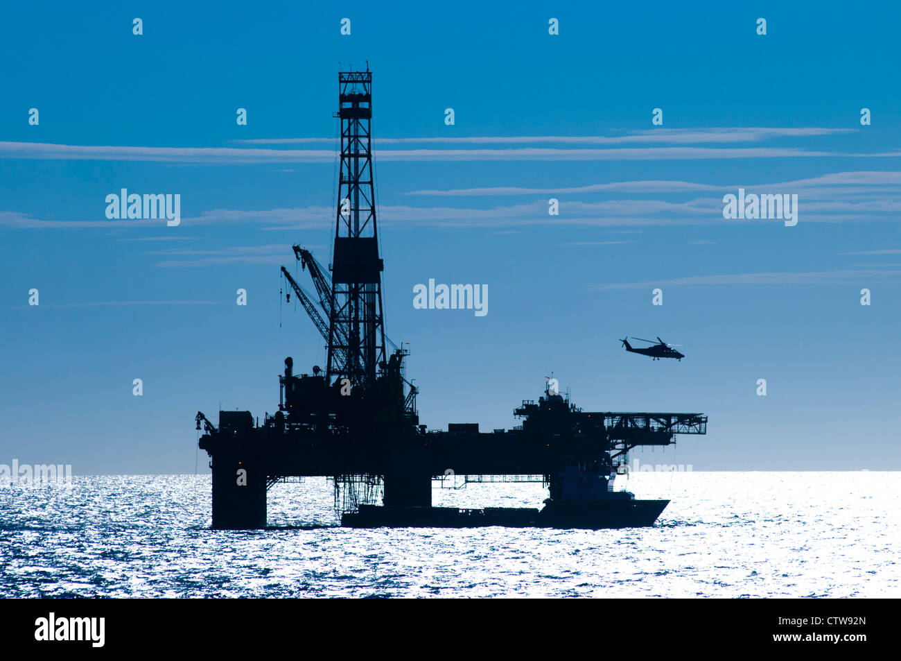 Silhouette von einer Öl-Bohrinsel im Offshore-Bereich.  Hubschrauber von es. Stockfoto