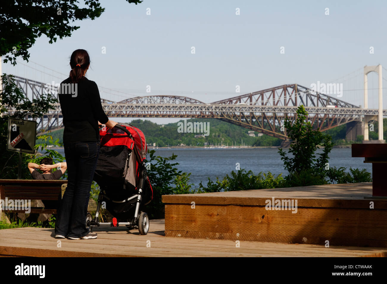 Eine Frau mit einem Kinderwagen, Blick auf die Pont de Québec-Brücke und den St.-Lorenz-Strom Stockfoto