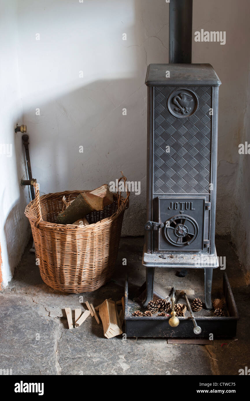 Kaminofen und einen Korb von Protokollen in der vorderen Zimmer von einem englischen Cottage. Großbritannien Stockfoto