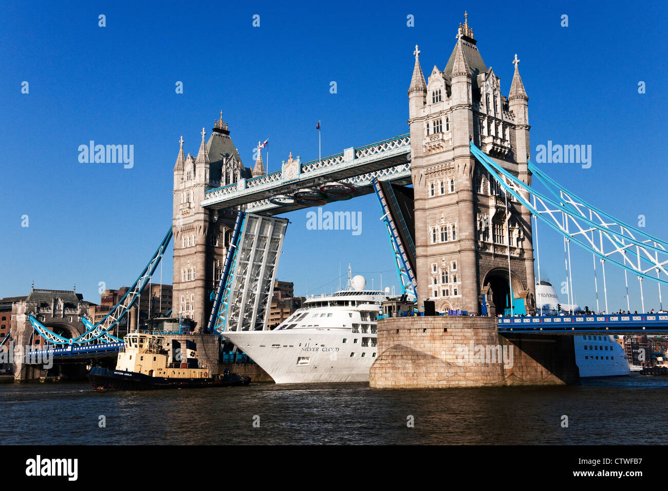 Der Silver Cloud Kreuzfahrtschiff unterquert die Tower Bridge mit Hilfe von einem Schlepper an einem hellen Sommertag Stockfoto