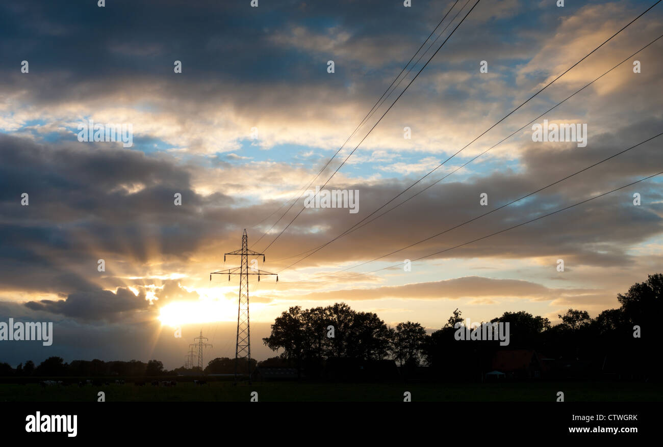 Strommasten gegen einen schönen gelb-orange-Sonnenuntergang Stockfoto