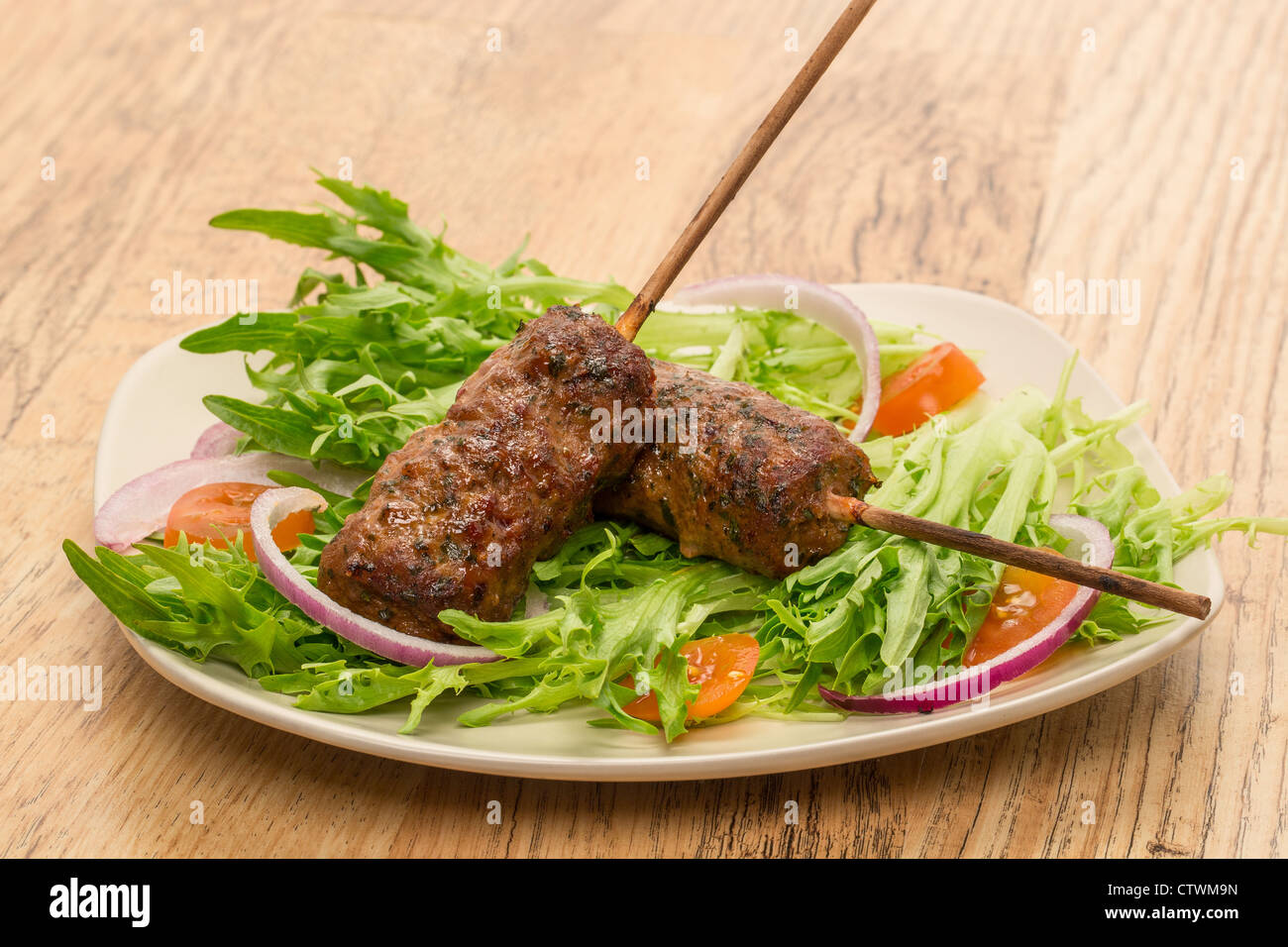 Rindfleisch-Schaschliks oder Kofta mit süßer Chili würzen und Petersilie serviert auf einem Bett von Salat - Studio gedreht Stockfoto
