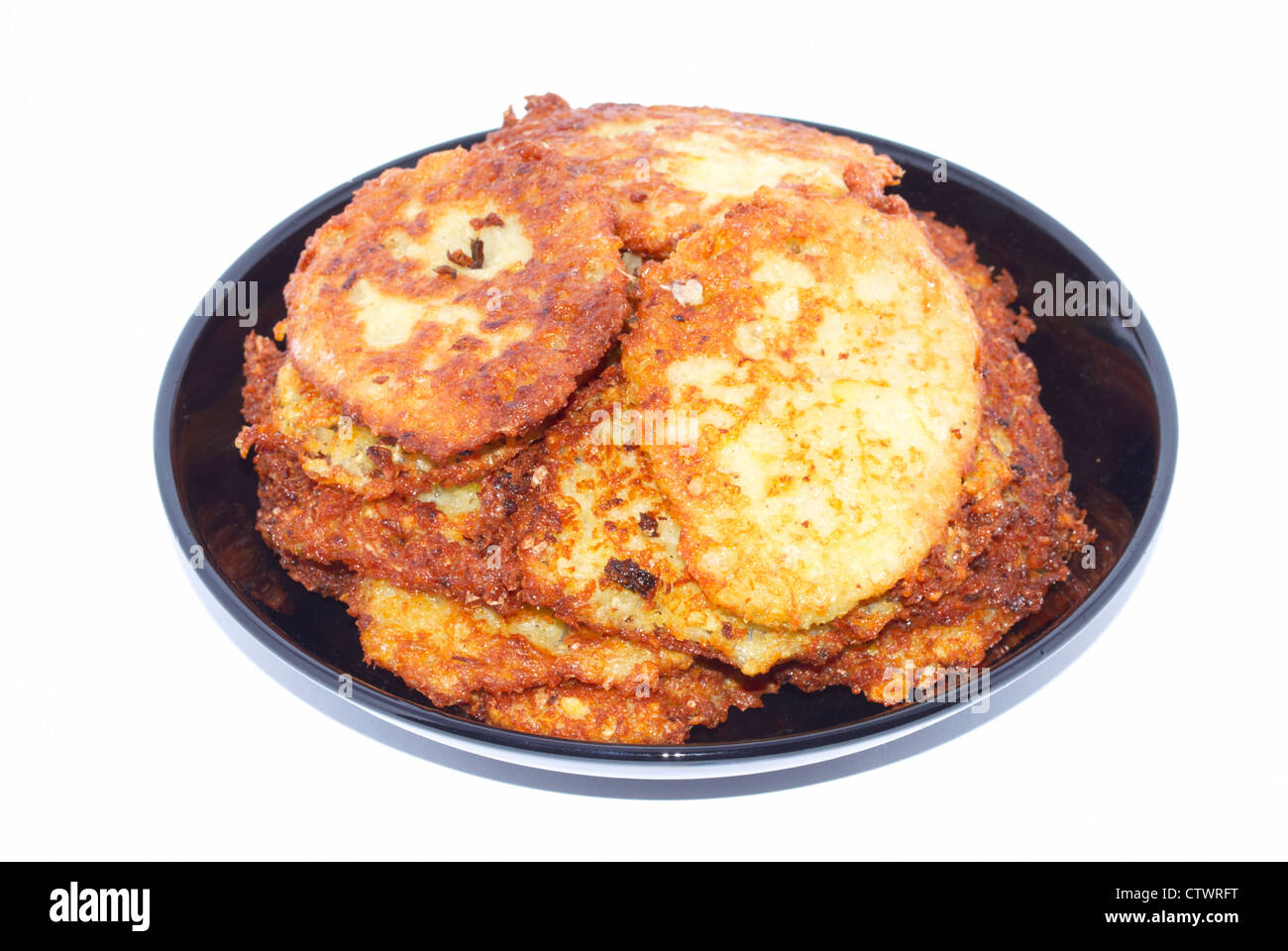 Kleine Kartoffelpuffer auf der schwarzen Platte Stockfoto