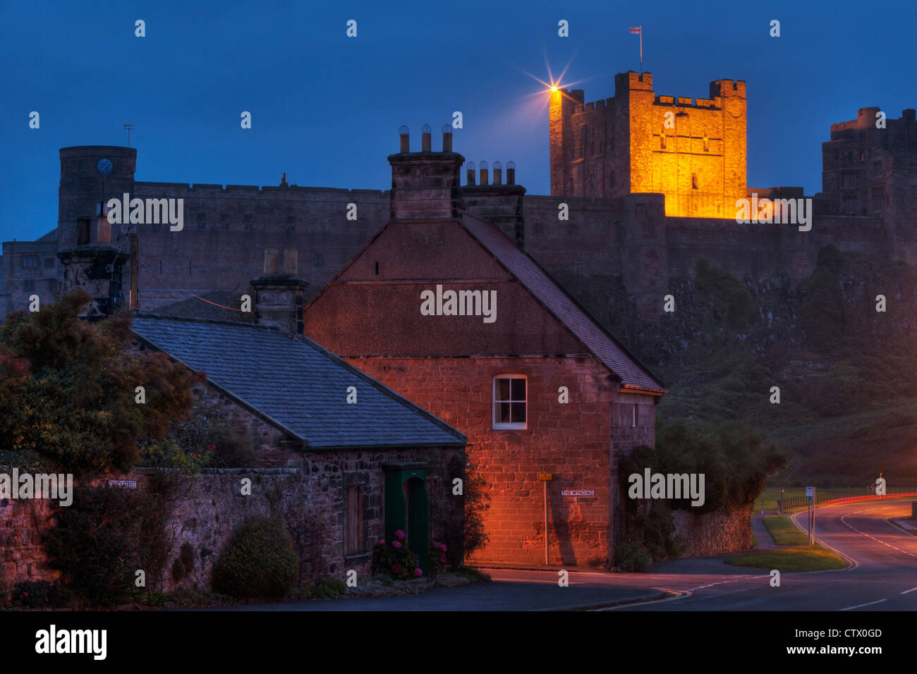 Bamburgh Castle in der Nacht beleuchtet. Die Burg mit Blick auf die Northumbrian Küste, Northumberland, England Stockfoto