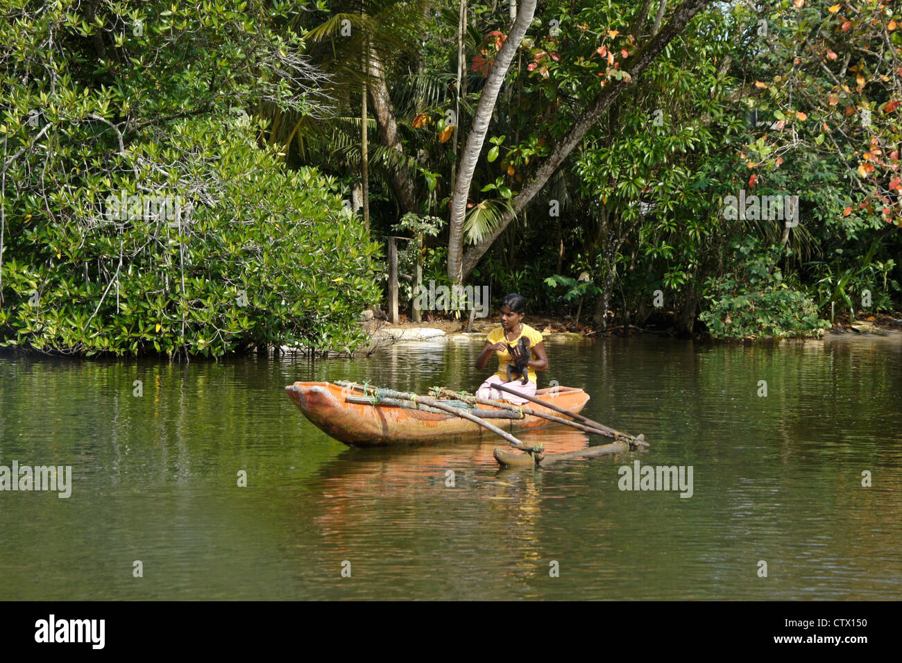 Mädchen mit Affen im Auslegerboot, Maduwa Fluss, Sri Lanka Stockfoto