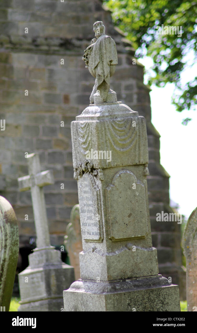 Alten Grabstein im Friedhof mit Kirche im Hintergrund. Stockfoto