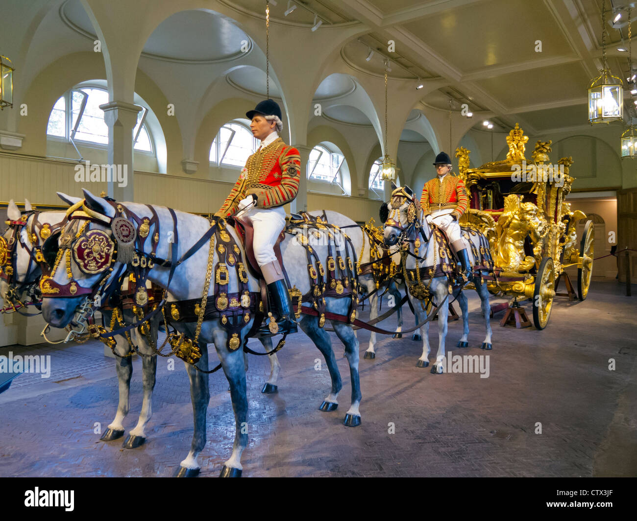 Die Gold State Coach mit montierten Reiter und Pferde, Royal Mews, London, England Stockfoto