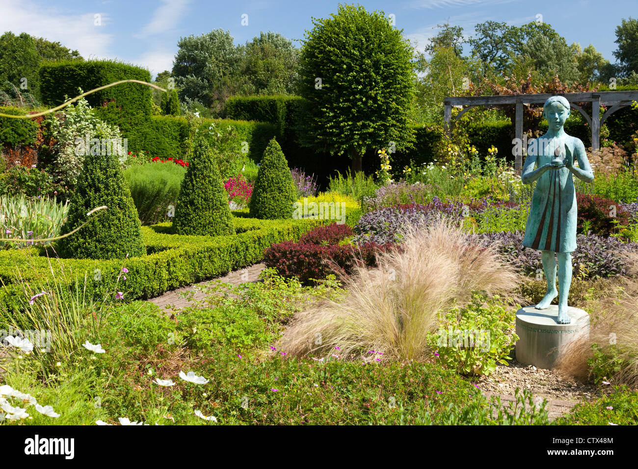 Waterperry Gärten - Skulptur des kleinen blauen Mädchens mit einer Laterne Stockfoto