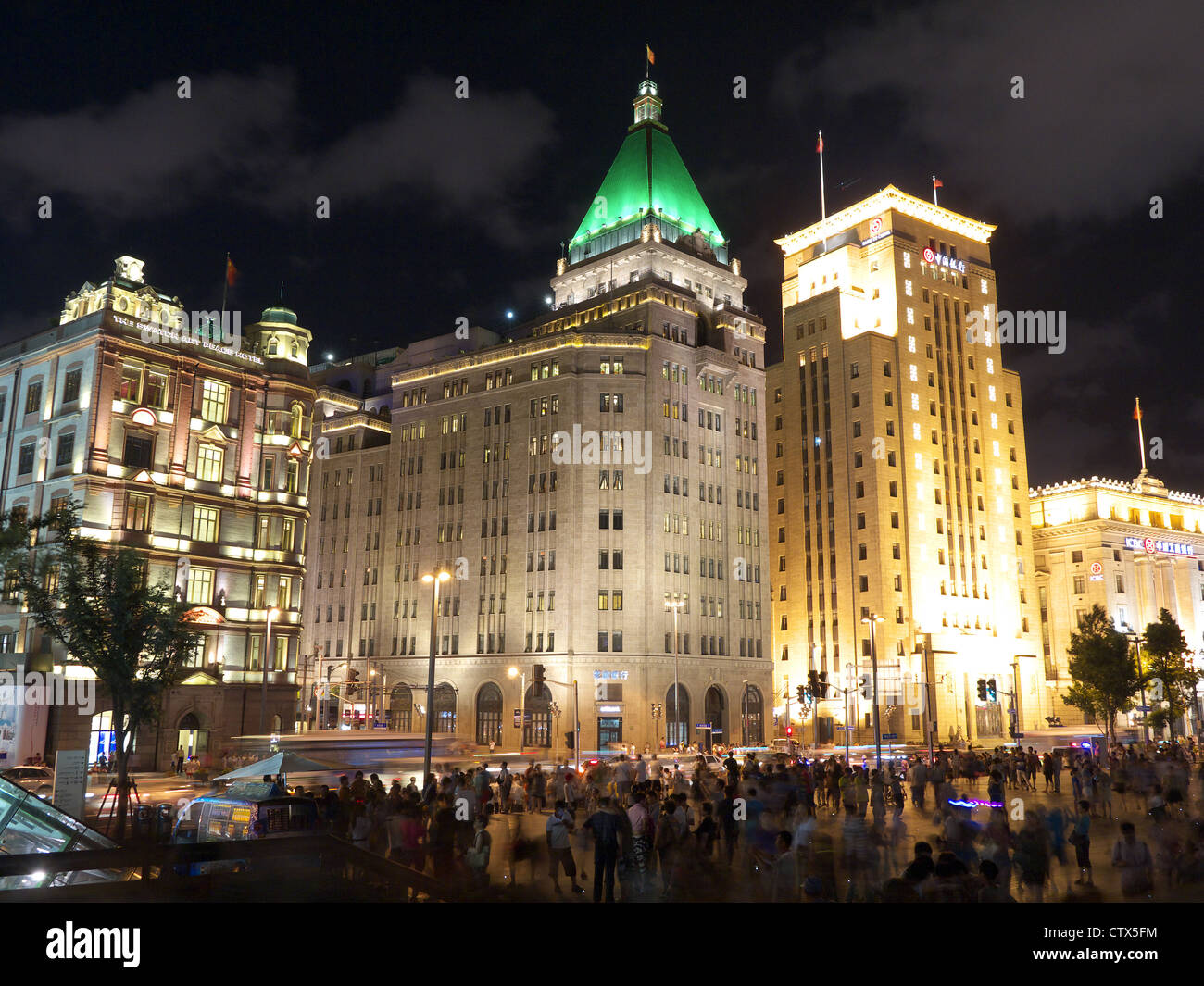 Ein Blick auf das Fairmont Peace Hotel beleuchtet und vom Bund in der Nacht in Shanghai China angeschaut Stockfoto
