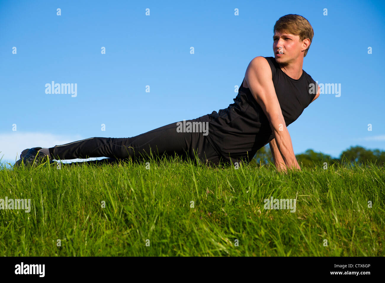 Sportler streckt seine Bauch- und Rückenmuskulatur Stockfoto