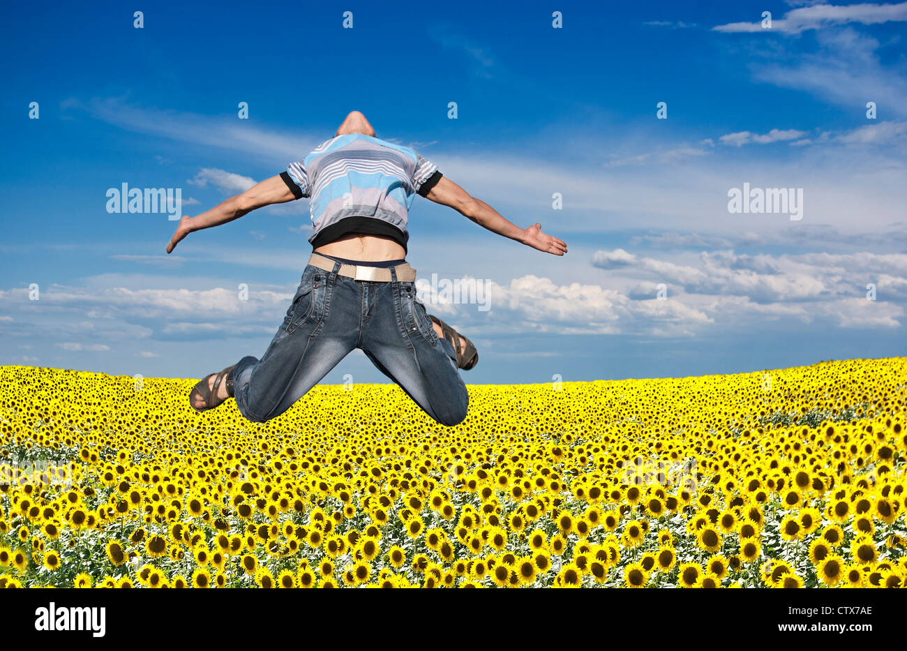 Junge springt vor dem Hintergrund des Feldes und des Himmels Stockfoto