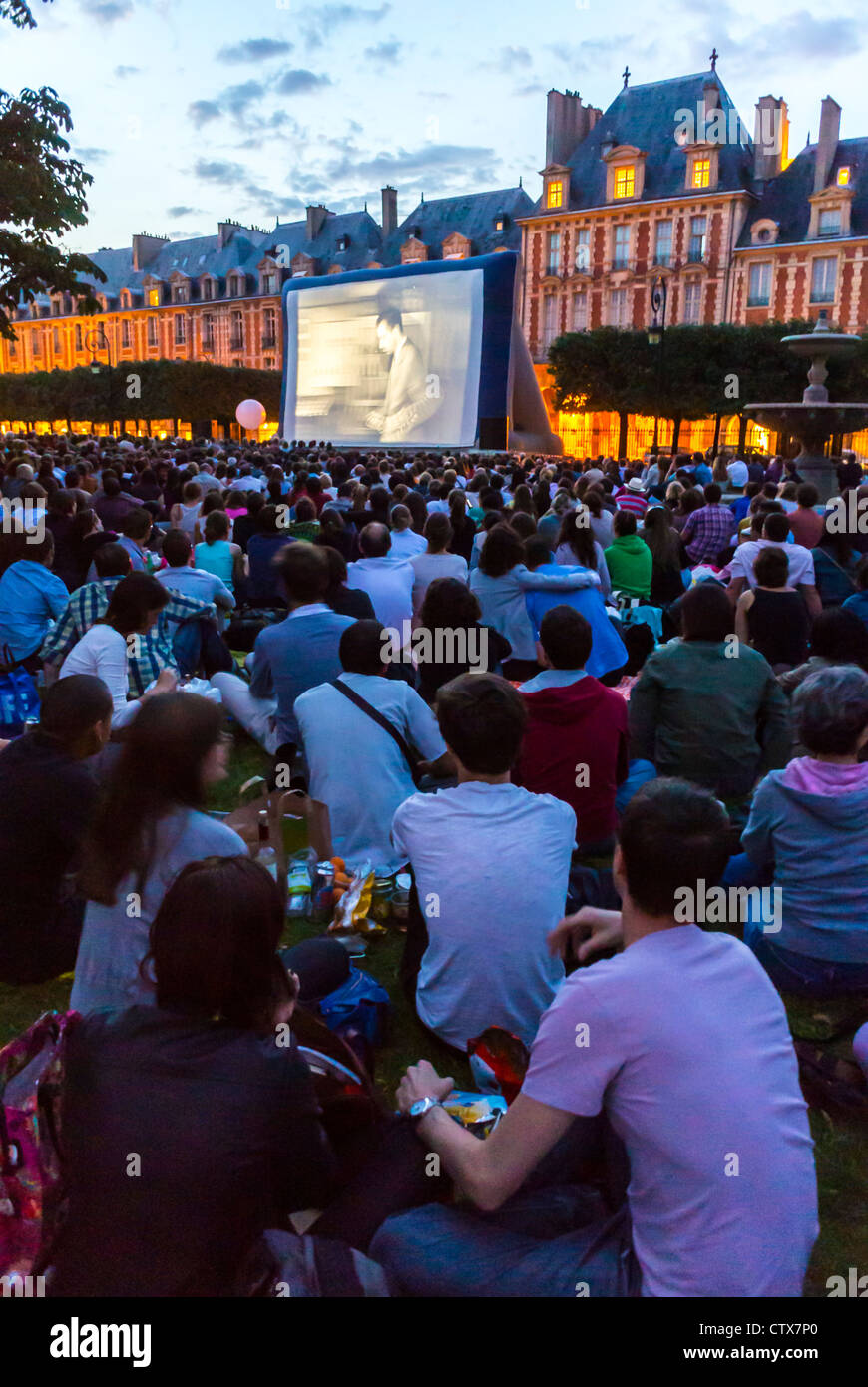 Paris, Frankreich, Open Air, Kino, Forum des Images, auf dem Marktplatz „Place des Vosges“ im Marais-Viertel sitzen viele Menschen auf dem Rasen von hinten in den Filmen Stockfoto