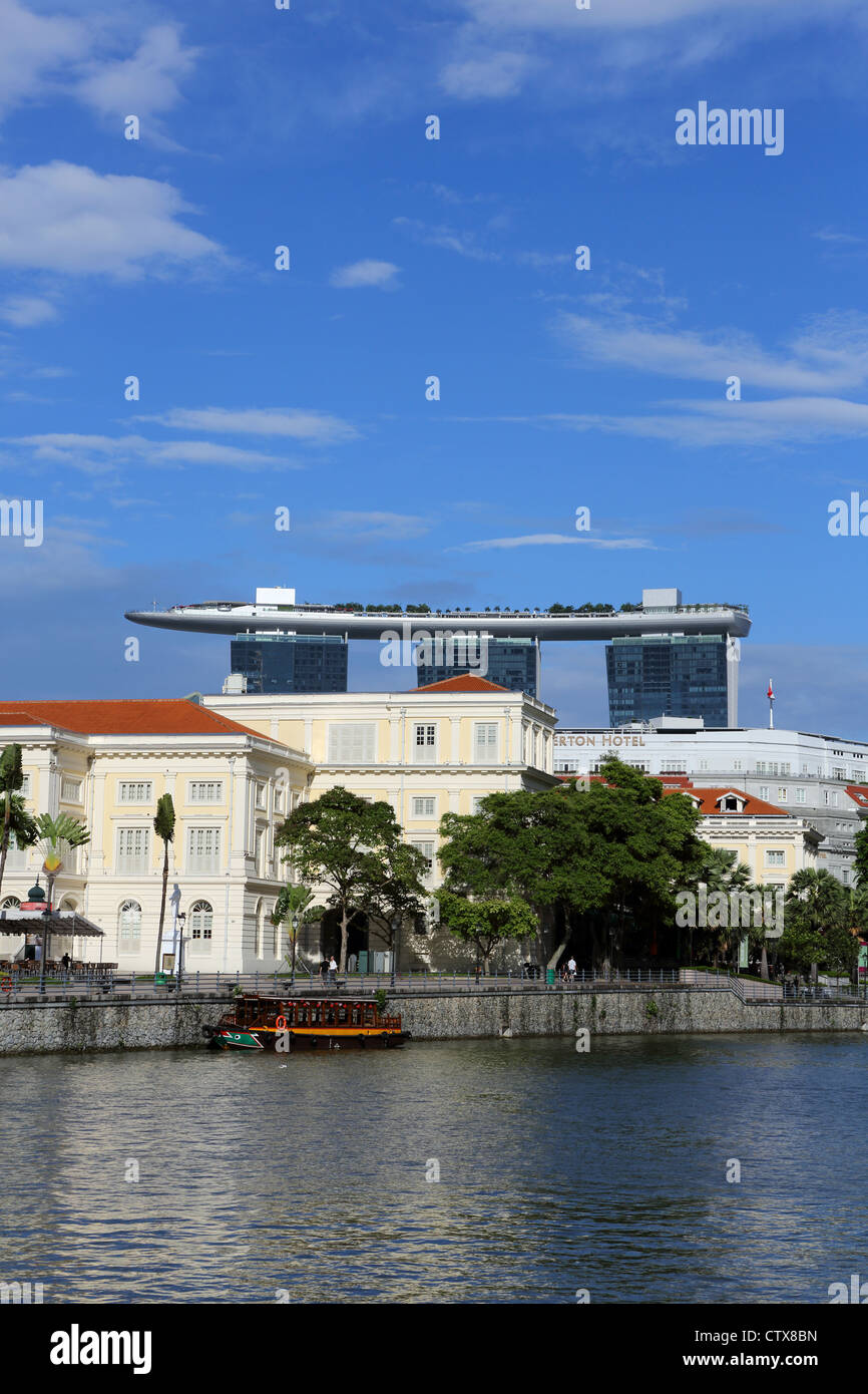 Holzfähre am Raffles Landeplatz auf dem Singapore River mit der Marina Bay Sands Skypark hinter. Stockfoto