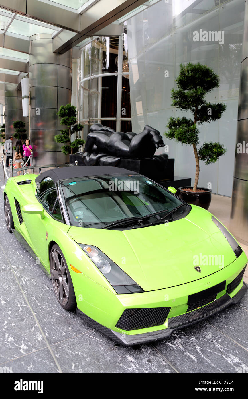Grün-Lamborghini Sportwagen im Hotel Vorplatz mit Fernando Botero Skulptur hinter geparkt. Stockfoto