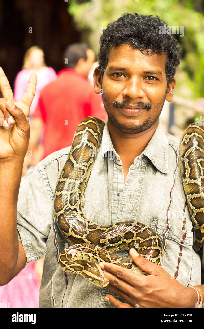 ein indischer Schlangenbeschwörer ist mit Schlange in Batu Höhle von Kuala Lumpur, Malaysia als Straßenmusikant. Stockfoto