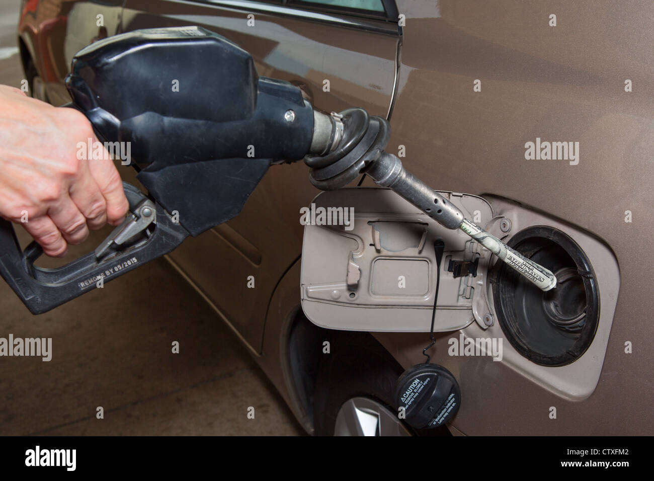 Pumpt Geld in Gas-Tank Stockfoto