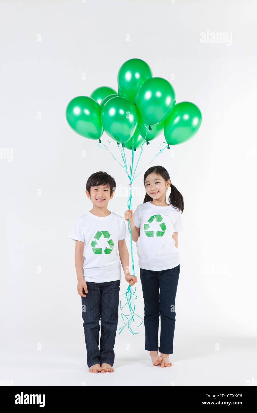 Kinder tragen recycling Hemd mit grünen Luftballons Stockfoto