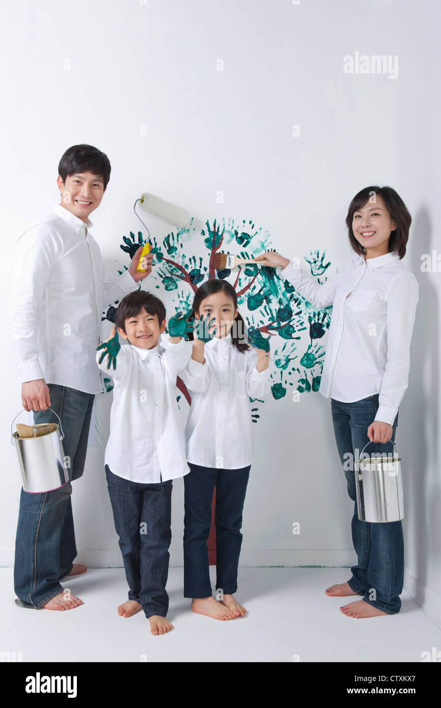 Eine Familie, die den Baum an die Wand malen Stockfoto