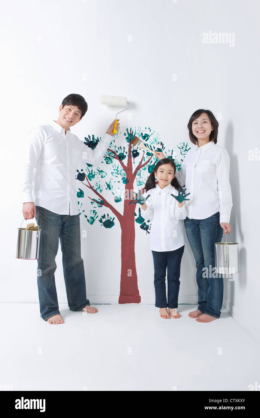 Eine Familie, die den Baum an die Wand malen Stockfoto