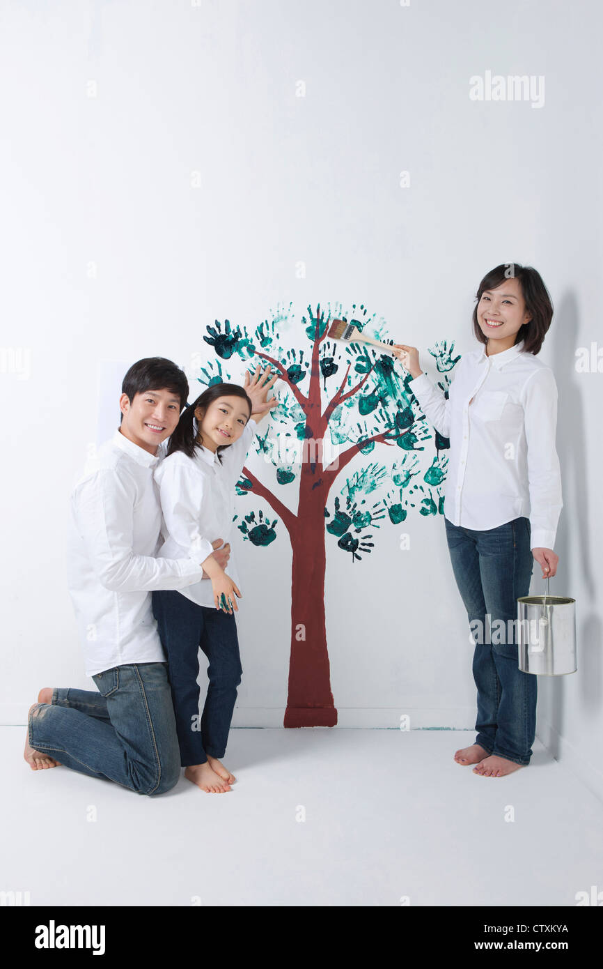 Eine Familie, die den Baum an die Wand malen Stockfoto