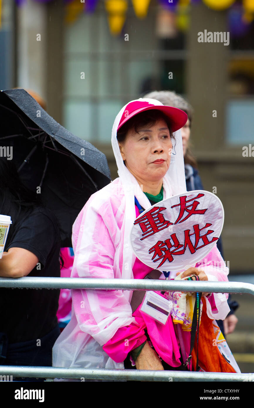 Japanische Leichtathletik Anhänger wartet in Regen für Frauen Marathon, Olympic, Spiele, London 2012. Stockfoto