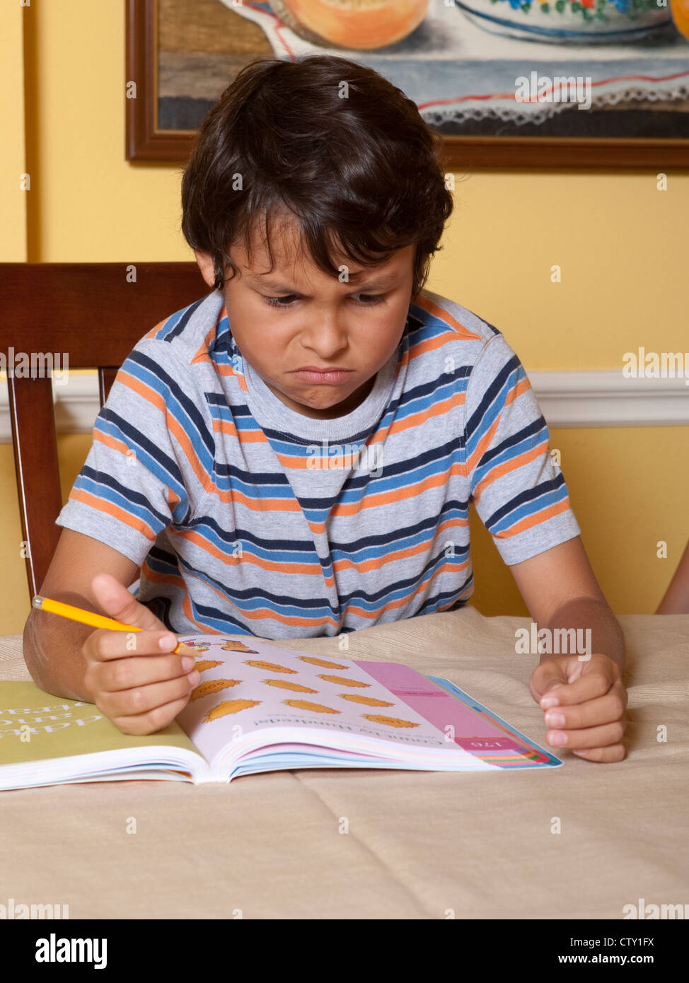 8 Jahre alten mexikanisch-amerikanischen jungen wird frustriert mit Textaufgabe aus Schulbuch Arbeit zu Hause Stockfoto