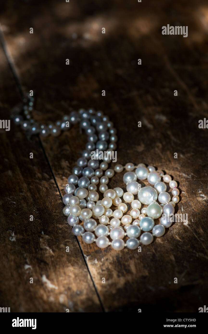 Perlenkette auf alten Eichen Dielen im Sonnenlicht Stockfoto