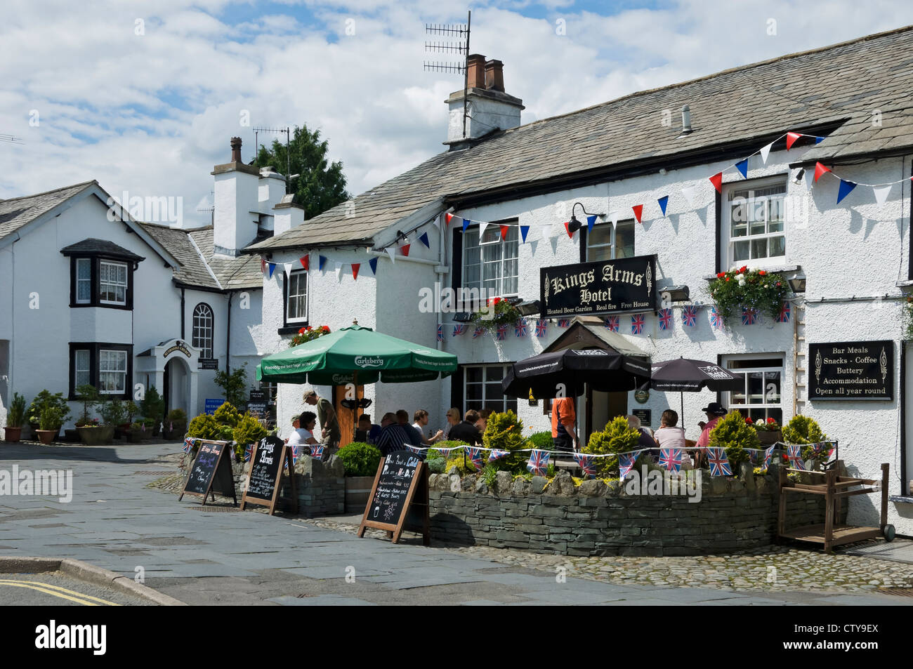 Menschen Besucher Touristen sitzen vor dem Kings Arms Hotel Dorf Pub im Sommer Hawkshead Cumbria England Vereinigtes Königreich GB Großbritannien Stockfoto