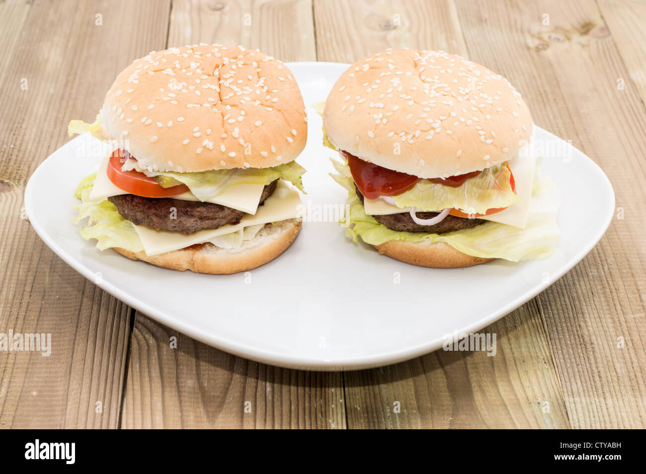 Zwei Cheeseburger auf einem Teller auf hölzernen Hintergrund Stockfoto