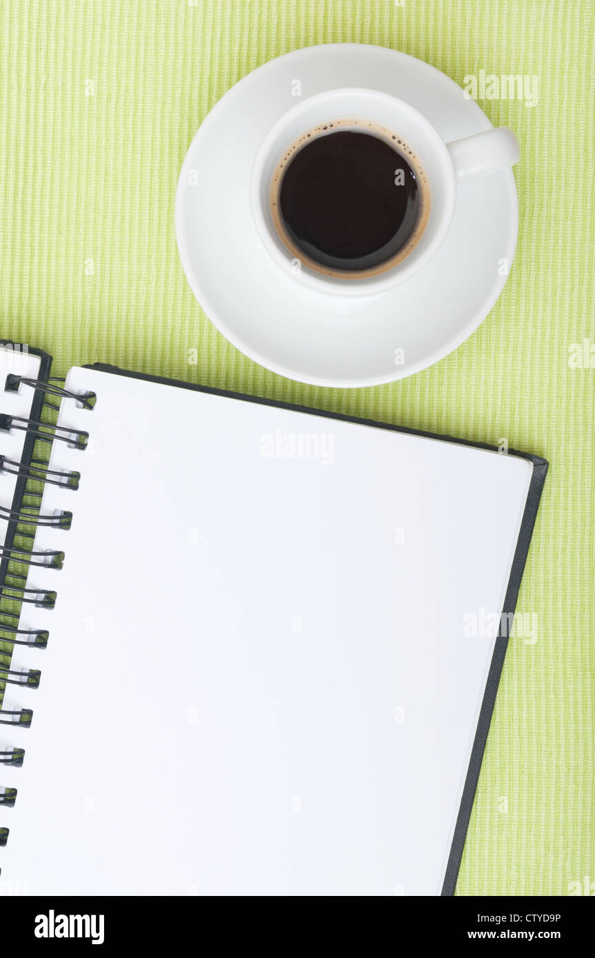 Nahaufnahme von leeren Tagebuch und Tasse Kaffee am Tisch Stockfoto