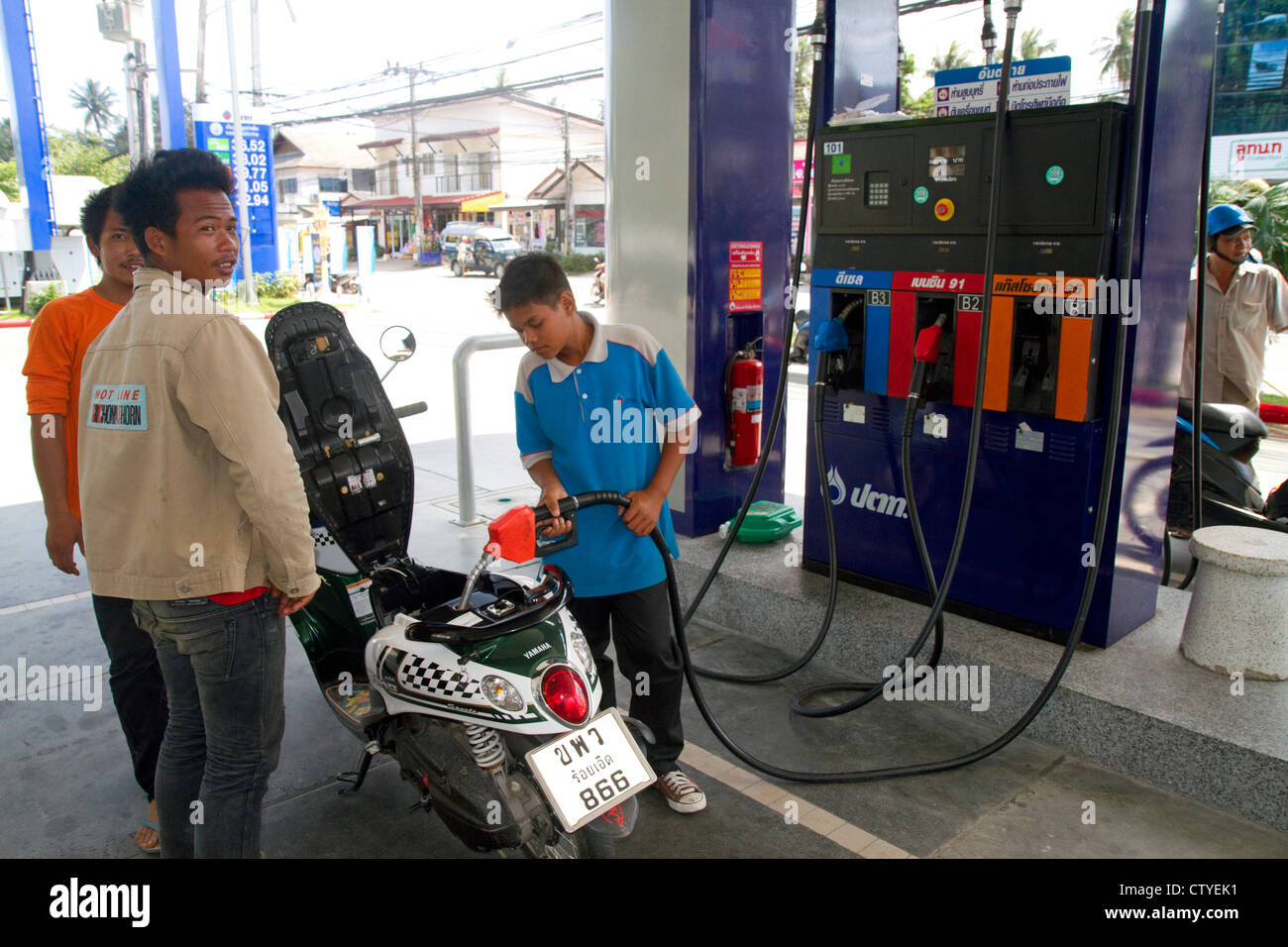 Tankwart füllt sich ein Motorroller auf der Insel Ko Samui, Thailand. Stockfoto